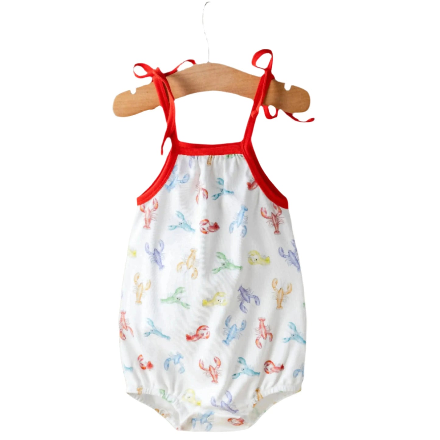 Baby romper with red straps on a hanger against a white background