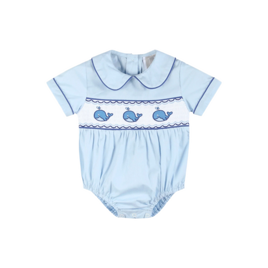Light blue baby romper with whale design on a gray background