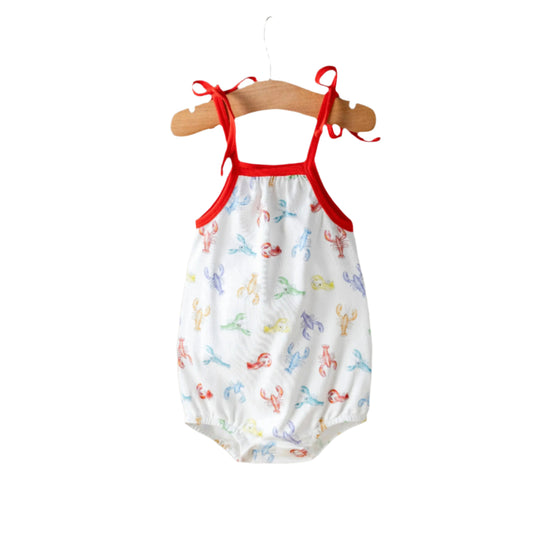 Baby romper with red straps on a hanger against a white background